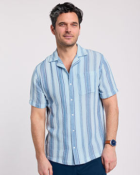 model wearing light blue striped button-down short-sleeved shirt
