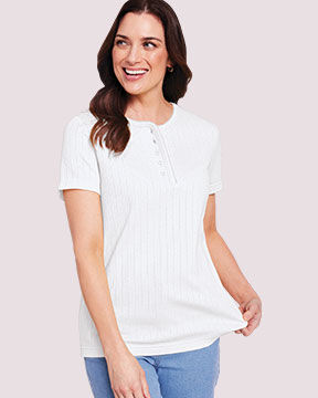 model wearing white top and blue jeans