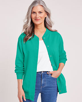 woman smiling into camera wearing green fleece jacket with white tee underneath