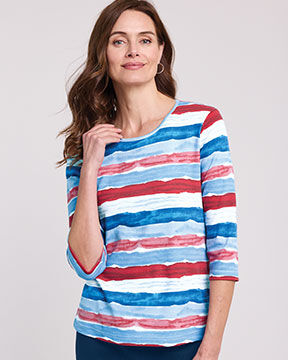model wearing red, white, and blue 3/4 sleeve shirt, blue jeans